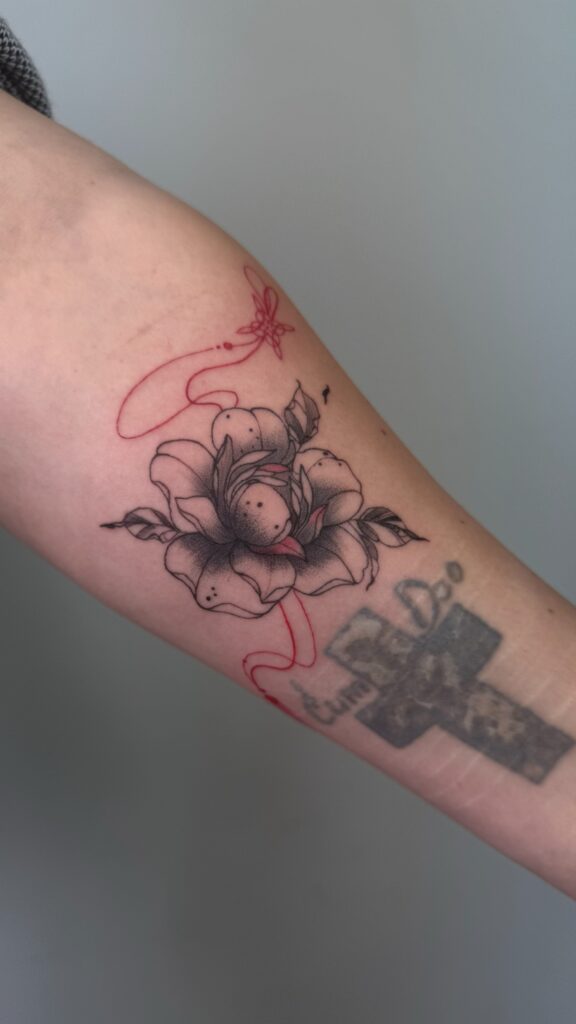 Тату квітка з червоною стрічкою на руці — робота учениці Skaty.Tattoo